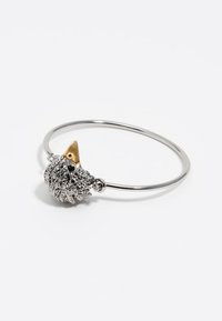 Pulsera de pulsera de plata con un diseño texturizado de erizo con acentos dorados. La pulsera tiene un acabado liso y pulido.