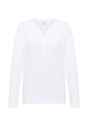 Camisa blanca de manga larga con escote en V y tapeta de cinco botones. Fabricada en un tejido suave, con una textura lisa y sin patrones.