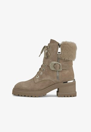 Taupe Wildleder Stiefeletten mit einem Pelzaufschlag, klobigem Absatz, Schnürung vorne, dekorativem Schnallenverschluss und seitlichem Reißverschluss. Strukturierte Gummisohle.