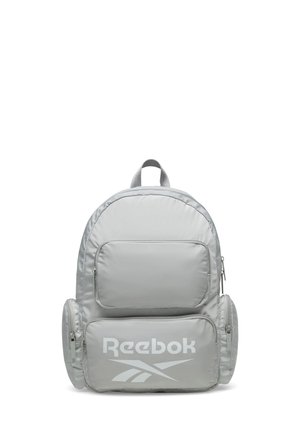 Jasnoszary plecak Reebok z wieloma kieszeniami zapinanymi na zamek oraz górnym uchwytem, z logo Reebok na przedniej kieszeni.