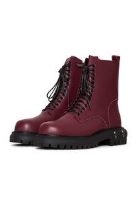 Botine din piele burgund cu sireturi negre, guler căptușit și talpă din cauciuc cu striații. Prezintă accente metalice și detalii de cusătură.
