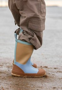 Light blue and tan rubber boots with brown soles, featuring a textured finish and round toe. Accented with a blue strap on the top.
