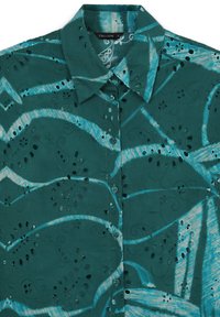 Türkises Hemd mit Knopfleiste und Paisleymuster, mit gestickten Ausschnitten und einem kontrastierenden hellblauen Wellenmuster. Aus weichem Baumwollmaterial.