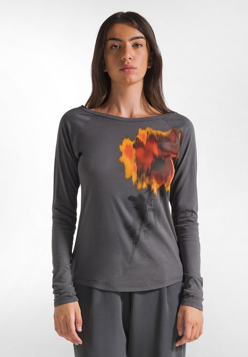 Graues Langarmshirt mit floralem Muster in Orange, Schwarz und Gelb. Glatter Stoff mit rundem Halsausschnitt und taillierten Ärmeln.