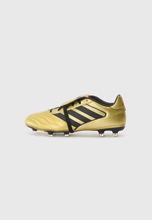 Gouden voetbalschoenen met zwarte accenten. Kenmerken zijn onder andere een gestructureerd leren bovenwerk, drie zwarte strepen en ronde noppen op de zool.