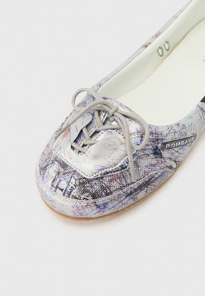 Κοντινό σε πολύχρωμο casual παπούτσι με αφηρημένα σχέδια, γκρι κορδόνια δεμένα σε φιόγκο και ετικέτα "ROMBAUT" στο πλάι.