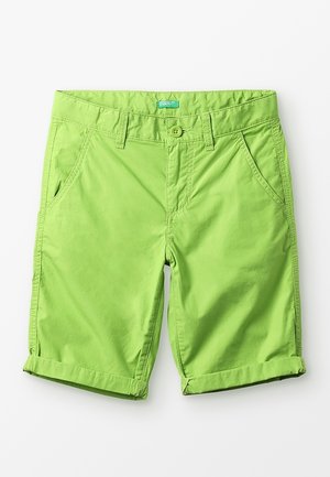 Shorts en coton vert vif avec fermeture à boutons, passants pour ceinture, poches avant et revers à bord roulé sur fond blanc.