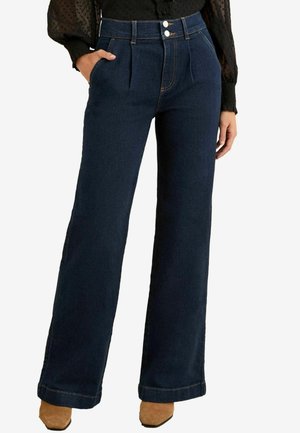 Sötétkék, magas derekú, széles szárú farmernadrág, elülső redőkkel, két gombos zárással és kontrasztos varrással. Puha denim anyag, oldalsó zsebekkel.