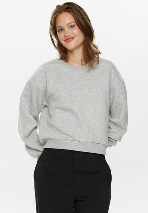 Grå kortärmad sweatshirt av mjukt tyg, med rund halsringning och långa, något oversized ärmar, i kombination med svarta byxor.