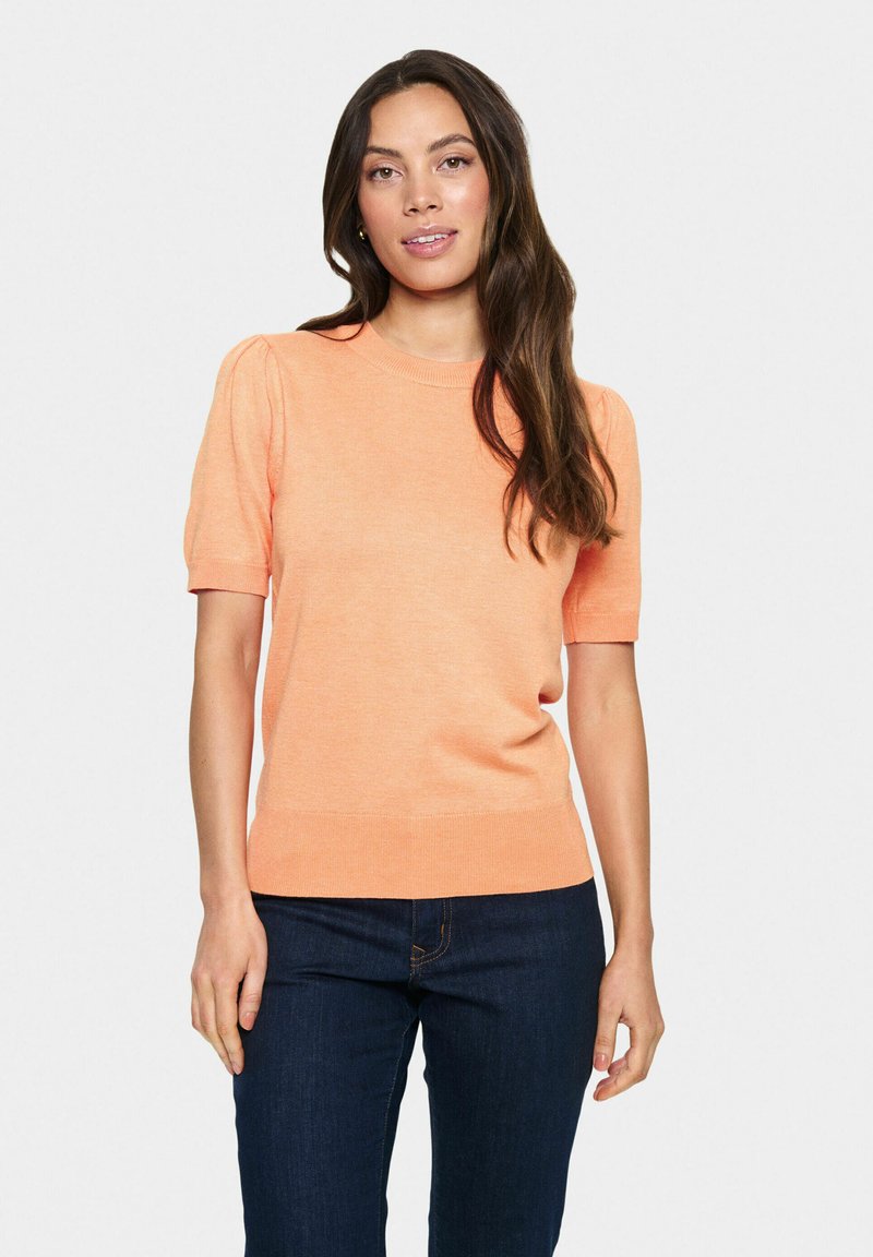 Pullover a maniche corte in arancione chiaro, realizzato in morbido tessuto a maglia; presenta un colletto e un orlo a coste aderenti, con dettagli arricciati sulle maniche.