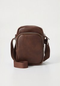 Brun læder skuldertaske med lynlåslukket hovedrum, justerbar rem og glat tekstur. Minimalistisk design med subtile detaljer.