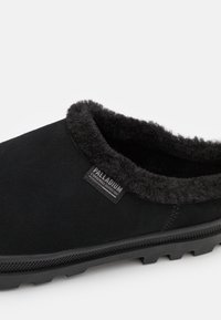 Czarne buty wsuwane z miękkim, teksturowanym wnętrzem i zewnętrzem. Gumowa podeszwa z bieżnikiem i małą metką z boku.