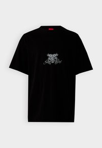 Black cotton t-shirt with a round neck, short sleeves, and a front graphic design in silver featuring floral and emblematic details.