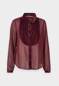 Burgundy srajca z žametnim sprednjim delom in prozornimi dolgimi rokavi. Ima ovratnik, zapiranje na gumb in mehko teksturo.