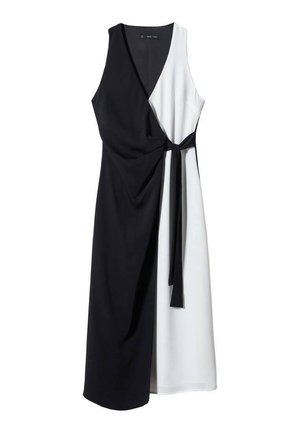 Robe sans manches en noir et blanc, présentant un design portefeuille, une ceinture à nouer, et une texture lisse aux couleurs contrastées.
