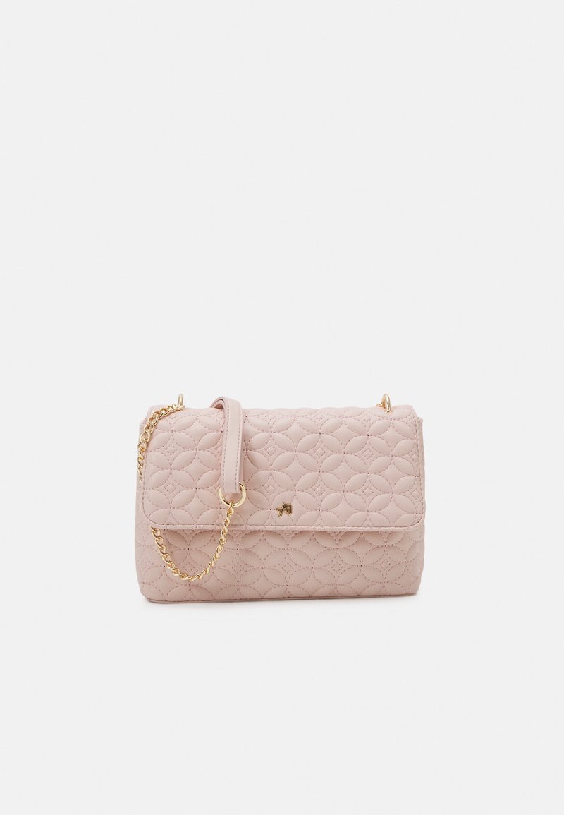 Bolso acolchado rosa con una correa de cadena dorada, cierre magnético y una textura suave. Presenta un logotipo sutil y esquinas redondeadas para un diseño compacto.