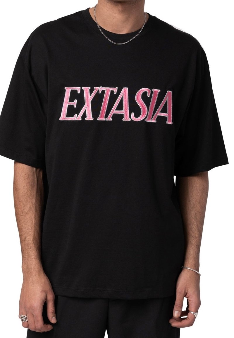 Černé oversized tričko s nápisem "EXTASIA" v tučně pískovém písmu. Vyrobeno z bavlny s krátkými rukávy a uvolněným střihem.