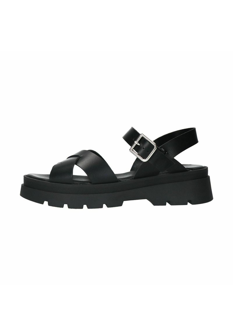 Black leather sandal with crisscross straps, adjustable ankle buckle, and thick, textured rubber sole. Features a lugged outsole for grip.