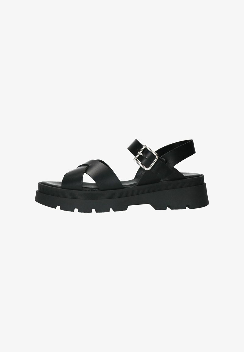 Black leather sandal with crisscross straps, adjustable ankle buckle, and thick, textured rubber sole. Features a lugged outsole for grip.