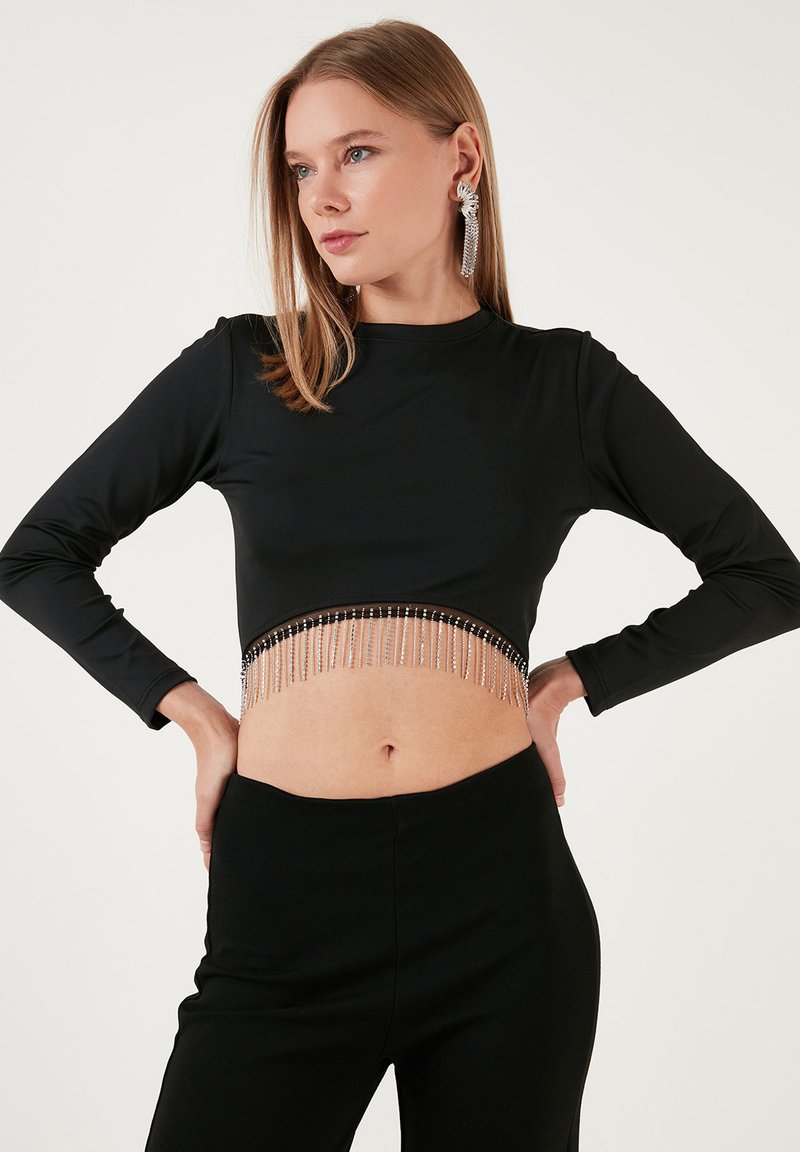 Čierny crop top s dlhým rukávom a detailom z perličiek na spodnom okraji, vyrobený z elastickej látky pre priliehavý vzhľad. Hladká textúra a elegantný dizajn.
