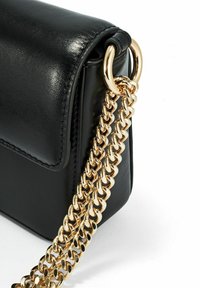 Czarna skórzana torba na ramię z złotym łańcuszkiem, gładką fakturą i prostokątnym kształtem z przeszyciami.