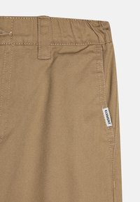 Tan woven trousers with a textured surface, featuring a straight fit and a small white label with "ELEMENT" on the side seam.