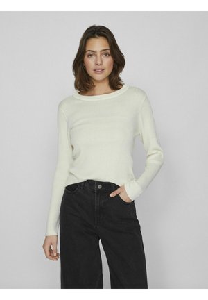 Suéter ligero de manga larga con canalé en color marfil, con cuello redondo. Combinado con jeans de pierna ancha negros de cintura alta.