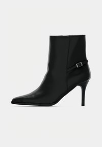 Μαύρα μποτάκια μέχρι τον αστράγαλο από λείο δέρμα με μυτερό μύτη και λεπτό, ψηλό τακούνι. Διαθέτουν διακοσμητικό λουράκι με αγκράφα.