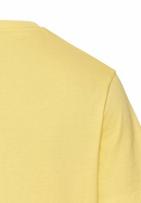 Gul kortærmet T-shirt, lavet af blødt bomuld, med en klassisk rund halsudskæring og glat tekstur med minimale syninger.