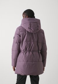 Ilgas pūkų paltas švelniai violetinės spalvos, su gaubtu, elastingu juosmeniu ir pasiūtu tekstūra su matomomis siūlėmis.