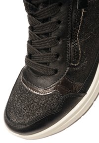 Schwarzer Sneaker aus strukturiertem Leder, mit glatten Akzenten und schwarzen Schnürsenkeln. Verfügt über einen seitlichen Reißverschluss und eine weiße Gummisohle.