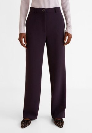 Pantalon large violet foncé avec une texture lisse, doté d'une fermeture à bouton à l'avant et de poches latérales, associé à des chaussures à imprimé léopard noir.
