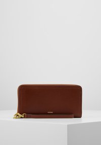Portefeuille en cuir marron avec finition texturée, mat�ériel doré, fermeture zippée et une bandoulière. Détail de logo subtil sur le devant.