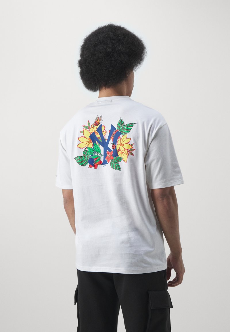 Camiseta de algodón blanca de manga corta con un gráfico floral colorido de flores amarillas, hojas verdes y acentos azules en la parte posterior.