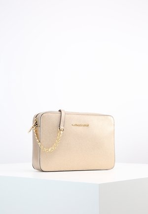 Beżowa prostokątna torebka Michael Kors z złotym łańcuszkowym paskiem i logo, prezentowana na białej powierzchni na jednolitym białym tle.