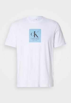 Valge lühikeste varrukatega T-särk, mille rinna kohal on helesinine ruut, millel on "cK Calvin Klein New York" teksti logo.