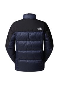 Mörkblå puffjacka med en svart övre sektion, med hög krage och sydda paneler. Inkluderar en logotyp på vänster axel.