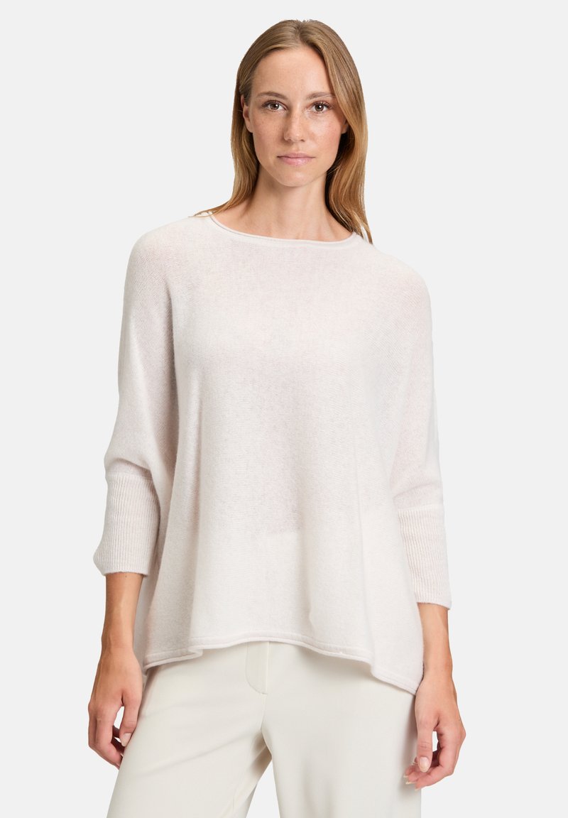 Pull léger de couleur crème avec un col rond et des manches 3/4. Texture douce, coupe décontractée et accents côtelés subtils aux poignets.