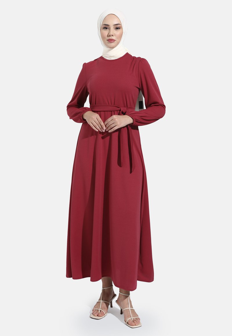 Bordeaux maxi-jurk met lange mouwen, ceintuur in de taille, ronde halslijn en zachte stof. Heeft een slanke silhouet met een enkel-lange zoom.