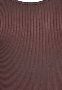 Ribitud, tumepunane kangas, mis on vooderdatud disainiga ja ümmarguse kaelusega. Tekstuur on sile ja silmapaistvate vertikaalsete joontega. Pole silmatorkavaid detaile ega aksessuaare.