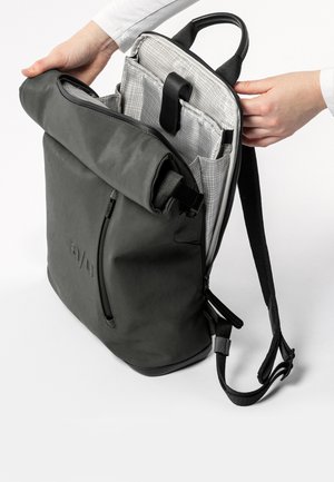 Grau rolltop Rucksack mit strukturiertem Oberflächenmaterial, ausgestattet mit einer Frontreißverschlusstasche, verstellbaren Trägern und einem gemusterten Innenfach.