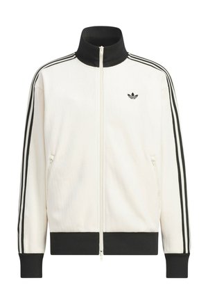 Weißes Trainingsjacke mit Reißverschluss, schwarzer Kragen, Bündchen und Saum; schwarze drei Streifen Details an den Ärmeln; kleines schwarzes Adidas-Trefoil-Logo auf der Brust.