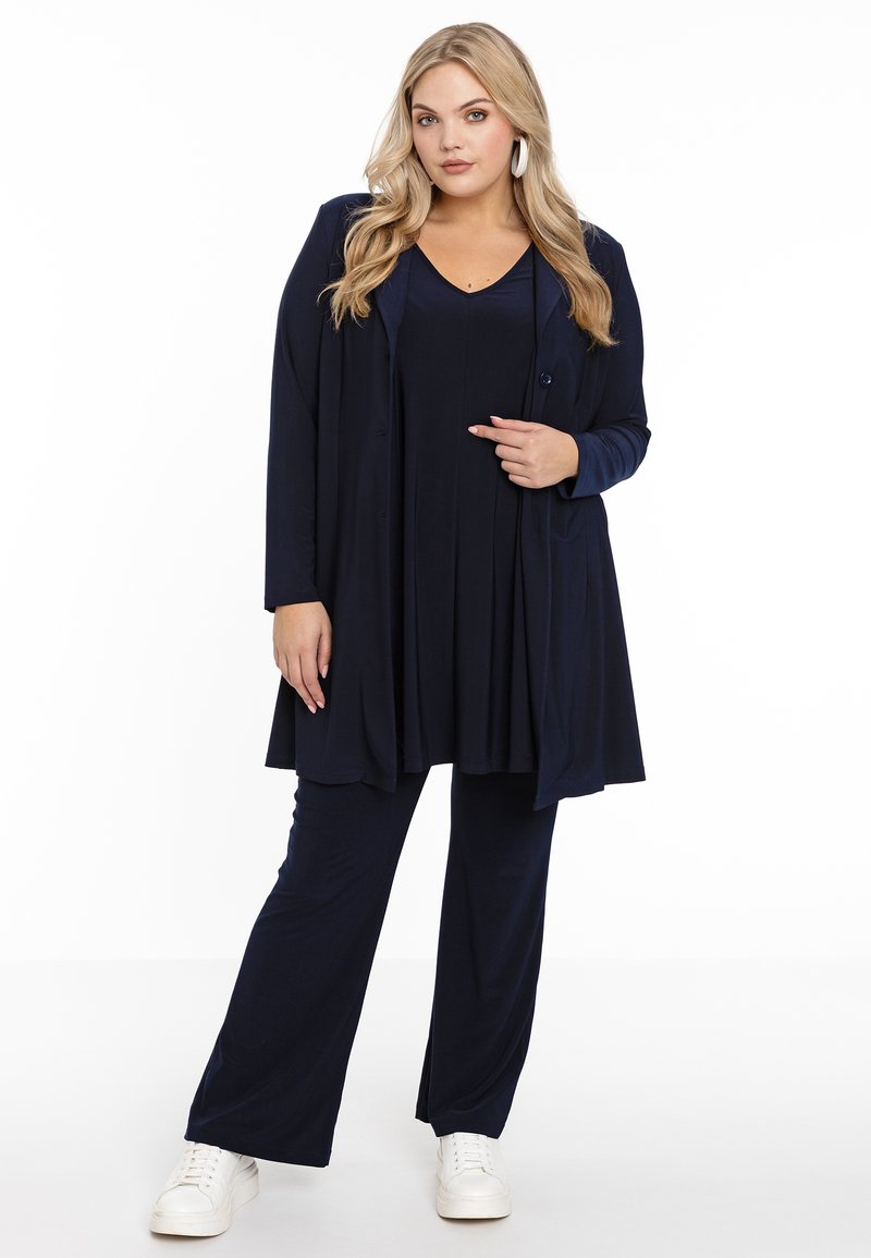 Marineblaue Dreiteiler-Outfit bestehend aus einem langen Cardigan, einem plissierten Oberteil und weiten Hosen. Der Stoff ist glatt mit einer einheitlichen Textur.