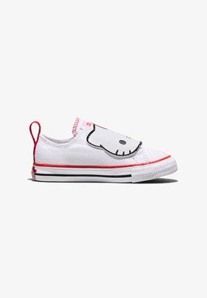 Baskets blanches en toile à enfiler avec un bord rouge, des rayures noires sur la semelle, et un rabat avec le visage de Hello Kitty sur le dessus.