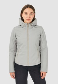Giacca softshell grigia chiara con cappuccio, dotata di zip frontale, tasche laterali e dettagli in oro sull'hardware, texture liscia.