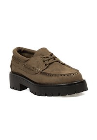 Zapatos de ante marrón con cordones, suela de plataforma negra gruesa y costuras prominentes. Incluyen una puntera redondeada y un cuello acolchado.