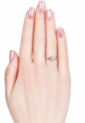 Gouden ring met een centrale heldere edelsteen, versierd met kleinere stenen langs een golvende band, tentoongesteld op een hand met lichtroze nagels.