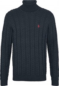 Marinblå kabelstickad turtlenecktröja med ribbade muddarna och nederkant. Har en liten röd logotyp på bröstet, tillverkad av strukturerat stickat material.