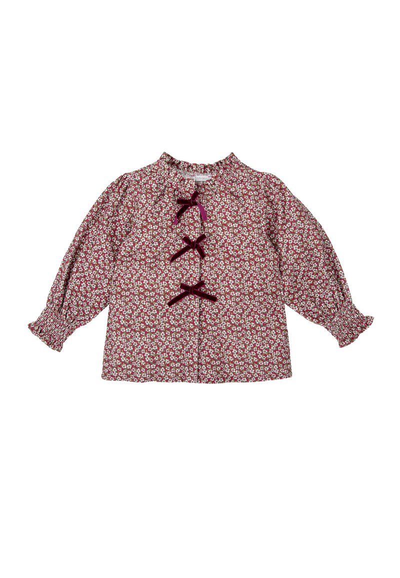 Blusa de patrón floral rojo con mangas largas y abullonadas, puños fruncidos y tres lazos de terciopelo en la parte frontal.