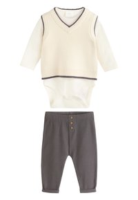 Cream ribbed vest with dark trim over long-sleeve bodysuit, paired with gray ribbed pants featuring three button accents.